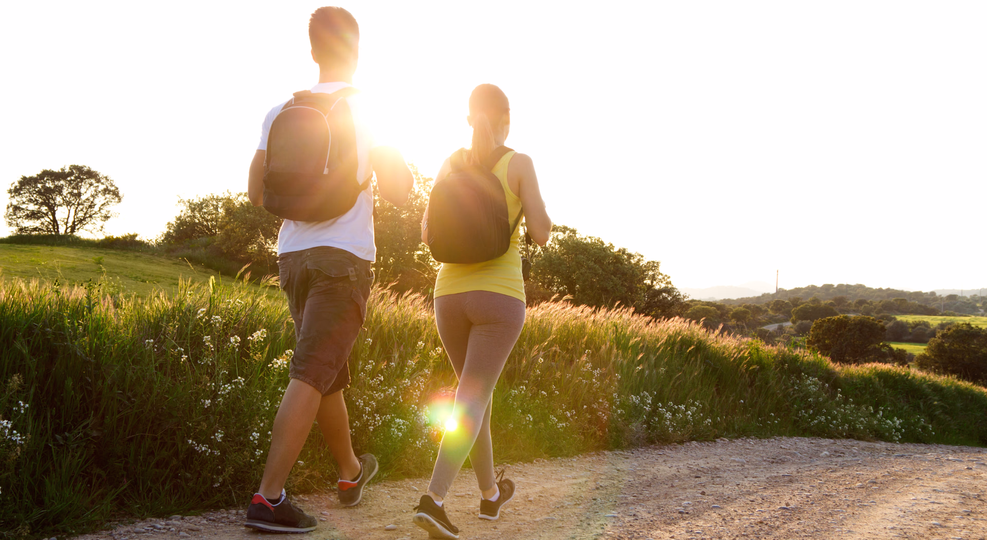 Pareja paseando por el campo en un día soleado.